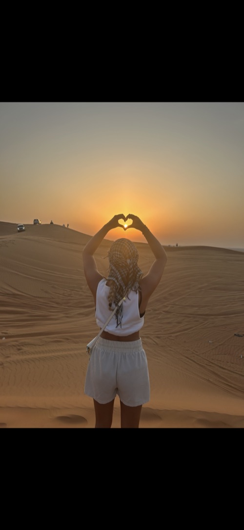 Belle making a heart shape at sunset in the desert