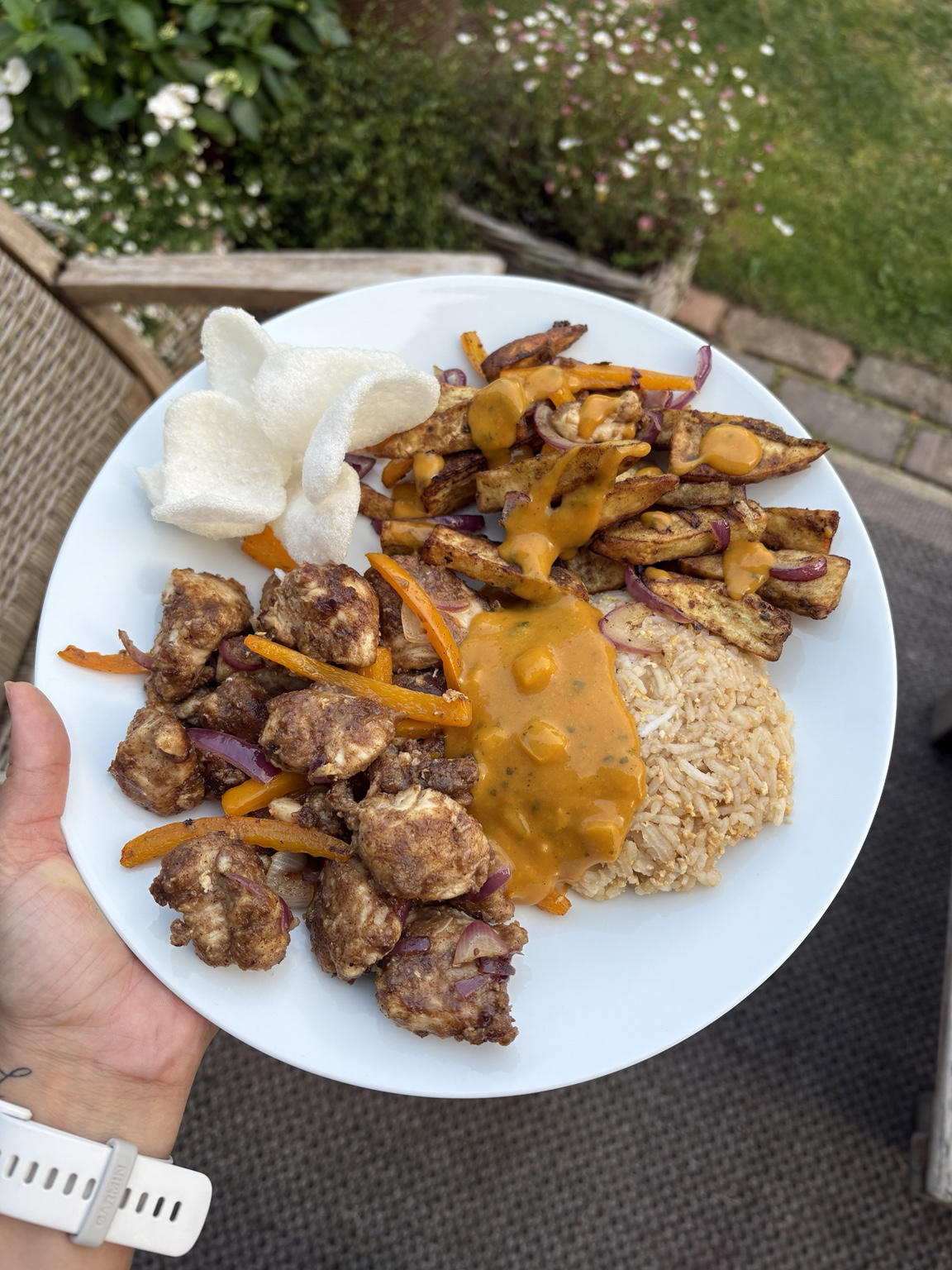 Chinese fakeaway plate with satay chicken, prawn crackers, spiced fries and rice