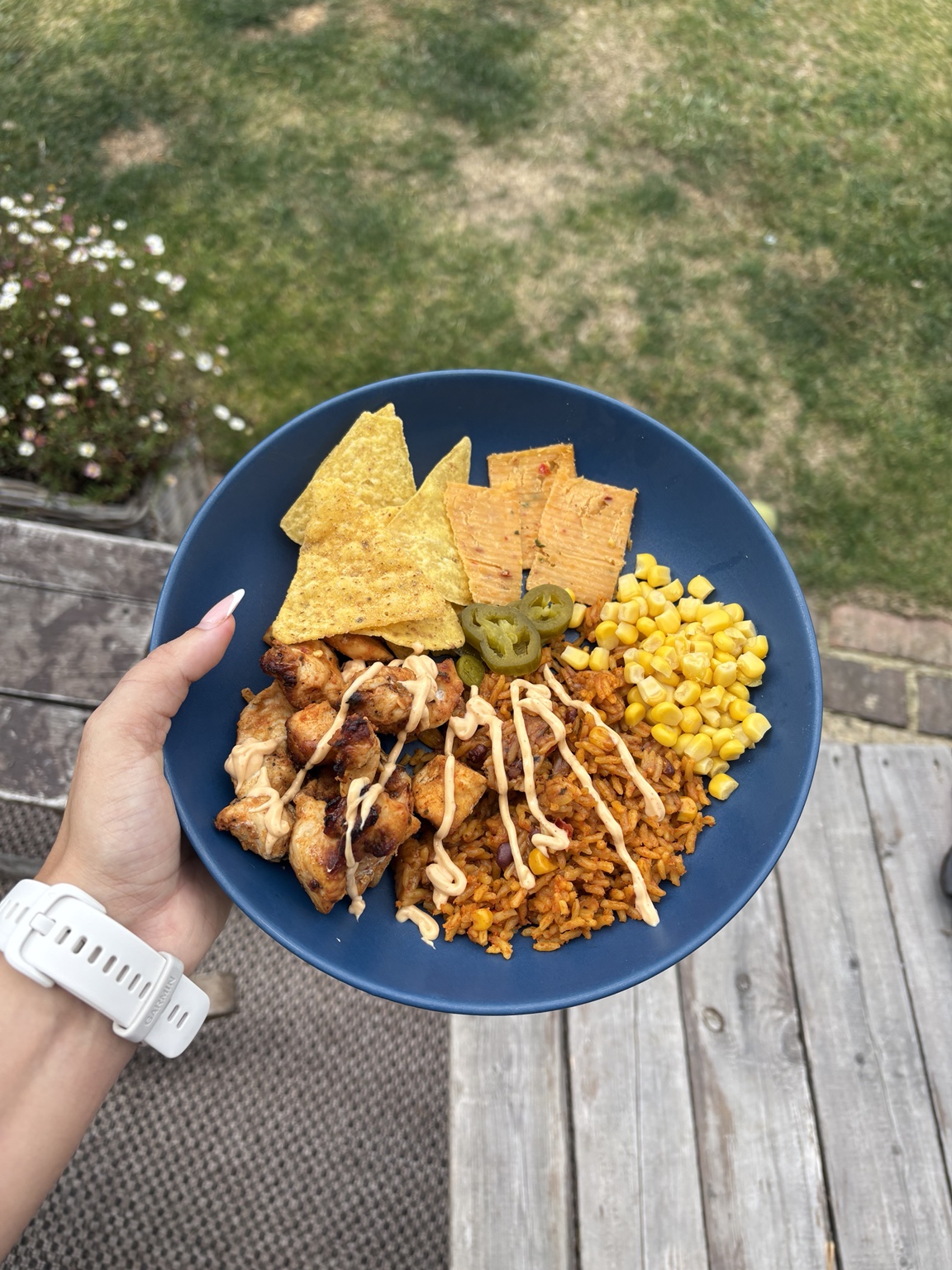 Mexican chicken bowl with spiced rice, sweetcorn, nachos and jalapeños